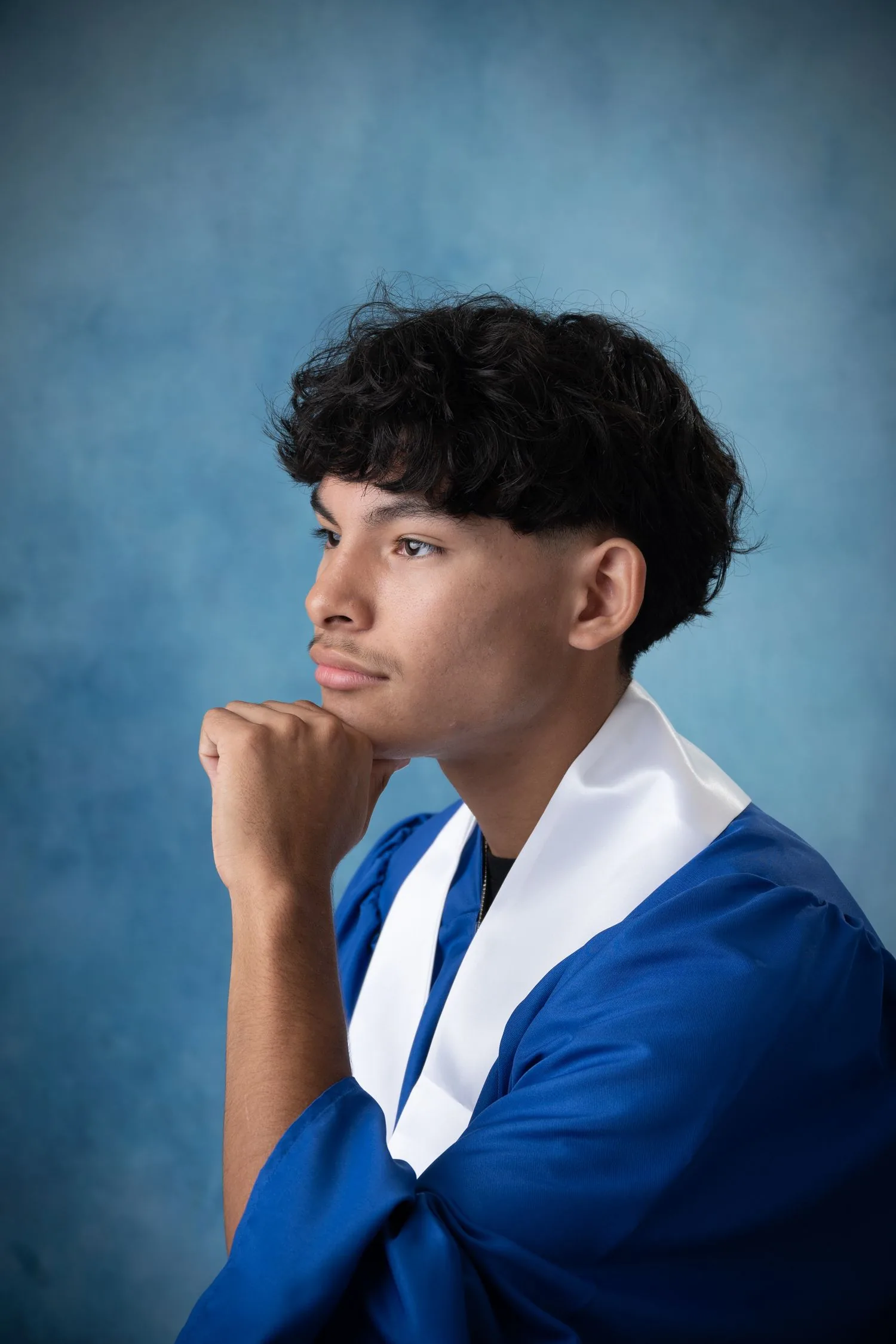 High school senior photographed in a formal graduation portrait