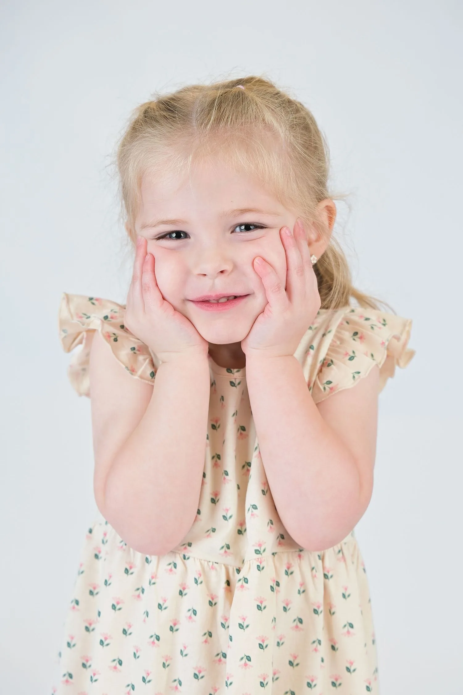 Preschool child smiling against a clean white studio background